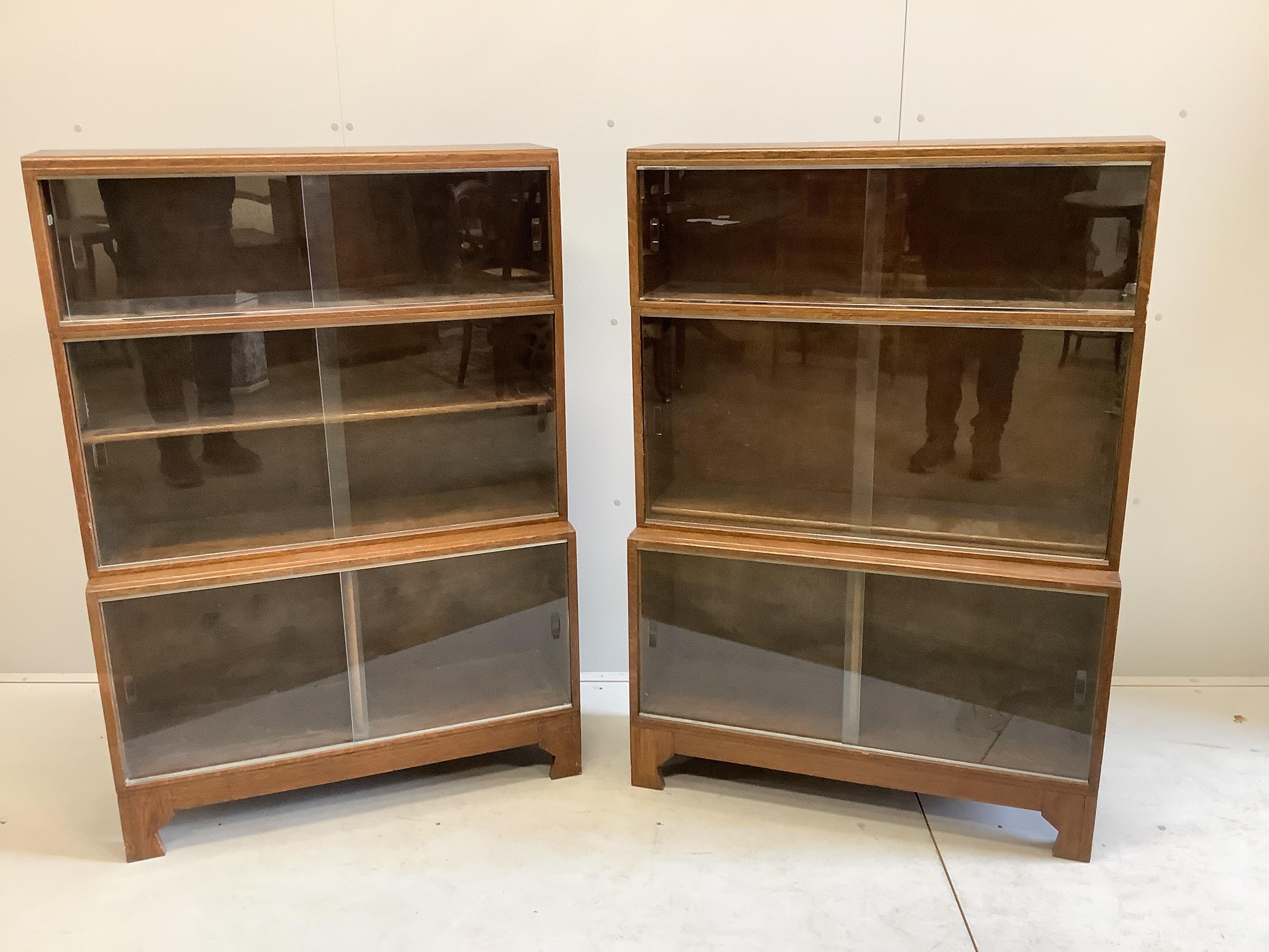 A pair of Minty glazed oak three section bookcases, width 89cm, depth 29cm, height 129cm